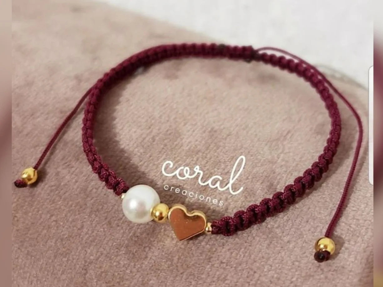 Pulsera tejida con detalle de perla y corazón